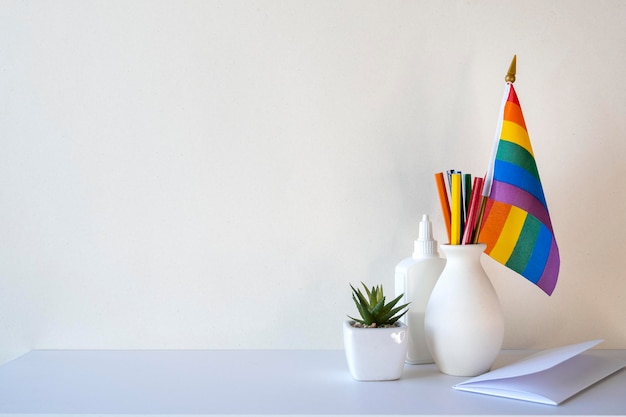 LGBT-Büroschreibtisch mit Regenbogenfahne und Schreibwarenleerwand mit Platz für Text