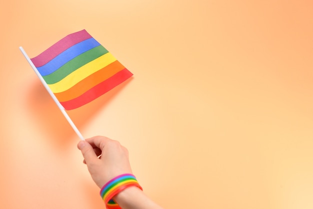 LGBT-Flagge in der Frauenhand auf Orange