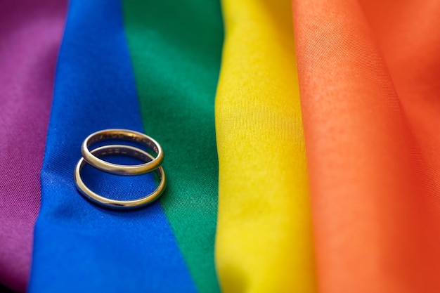 LGBT-Gay-Ehe Paar goldene Ringe auf regenbogenfarbenem Textil, Nahaufnahme Kopierbereich