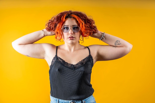 LGBT nichtbinäre Frau Selbstbewusstes und Furchtloses Tätowiertes Genderqueer Individuum auf gelbem Hintergrund