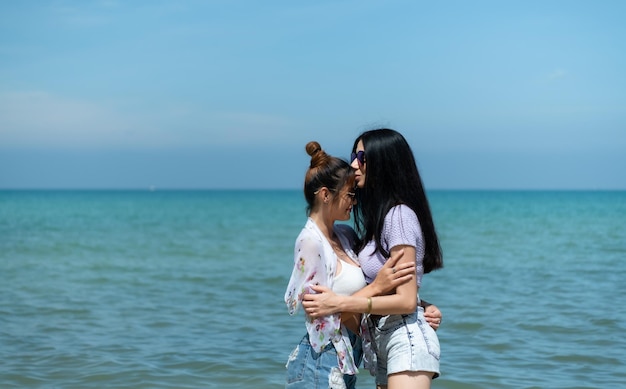 LGBT-Paare, die durch Asien reisen, schwimmen glücklich am Sandstrand mit dem wunderschönen blauen Meer