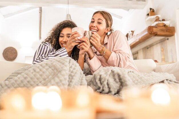 LGBT weibliches Paar, das Spaß unter einer Decke auf dem Sofa hat