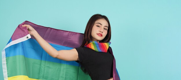 LGBTQ-Mädchen und Stolzflagge. sexy lesbisches Mädchen und LGBT-Flagge. blaugrüner Hintergrund.
