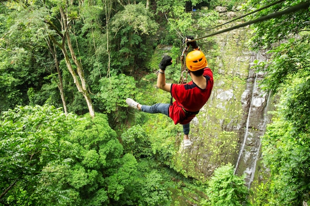 Liberdade adulto homem turista vestindo roupas casuais na tirolesa ou canopy Experience