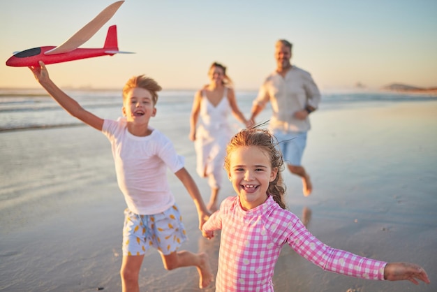 Liberdade família feliz e praia com crianças felizes correndo e brincando com os pais Viaje bem-estar e energia com crianças animadas se unindo e se divertindo rindo em atividades divertidas com mamãe e papai