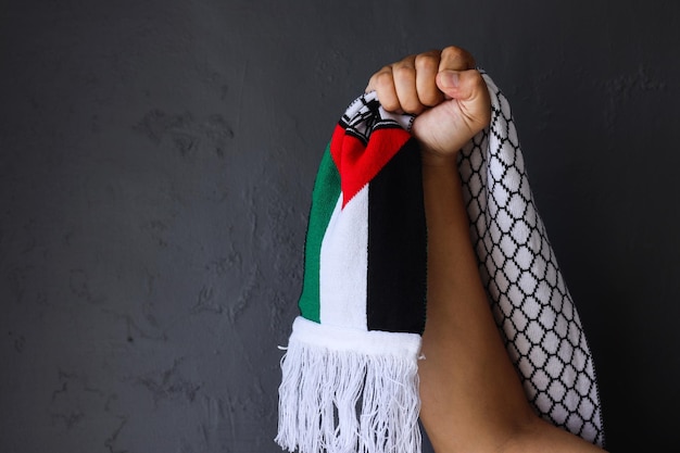 Foto liberdade para a palestina com a mão agarrando o lenço da palestina