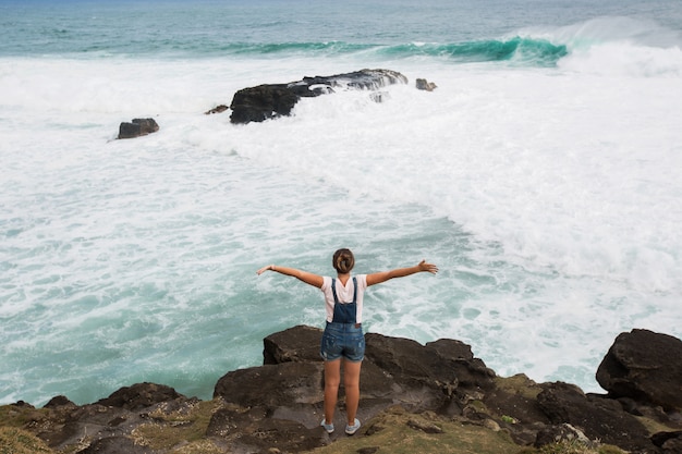 Liberdade viajante mulher em pé com os braços erguidos no topo da montanha e apreciar a bela vista do mar. Maurícia