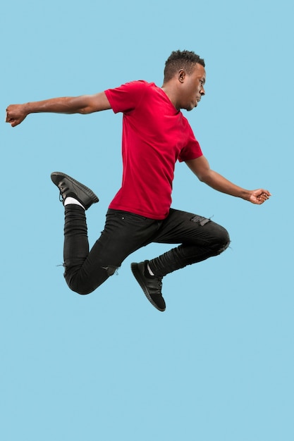 Libertad en movimiento y movimiento hacia adelante el feliz sorprendido joven afro saltando