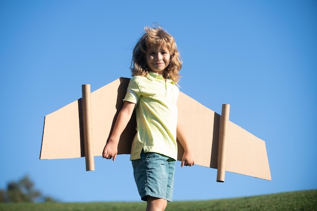 Libertad niños niño jugando a ser piloto de avión chico divertido con alas de cartón como un avión