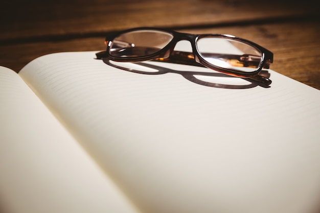 Libreta vacía con gafas para leer