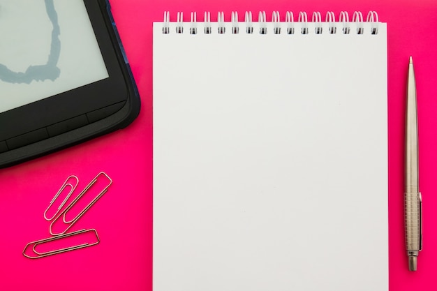 Libro abierto en blanco blanco de la libreta en fondo del concepto con los materiales de oficina.