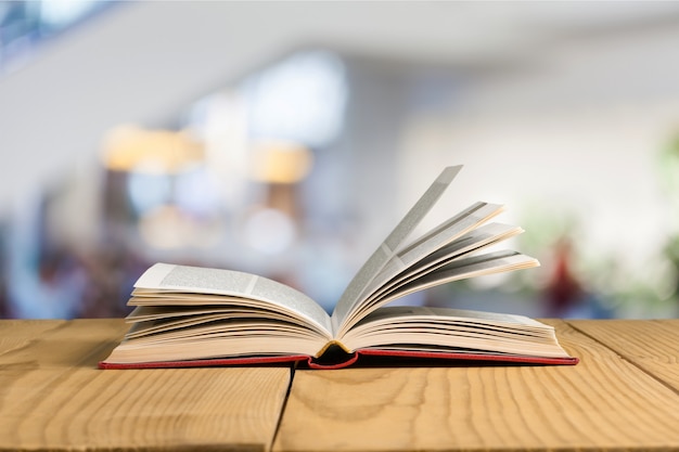 Libro abierto, libros de tapa dura sobre mesa de madera.