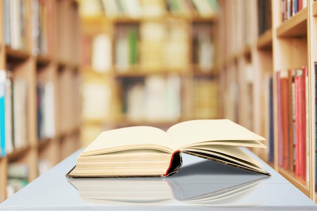 Libro abierto sobre una mesa de madera antigua en el fondo de la biblioteca