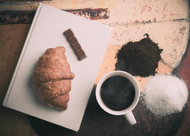 Foto libro al lado de la taza de café