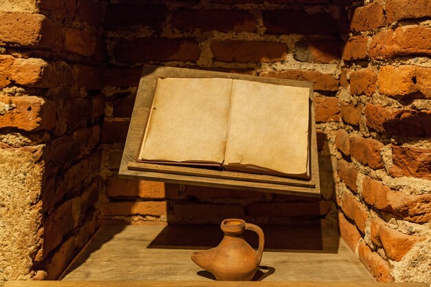 Libro antiguo con un tintero cerca de una pared de ladrillos. Libro antiguo con un tintero.