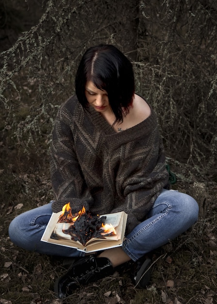 El libro arde en manos de una mujer.