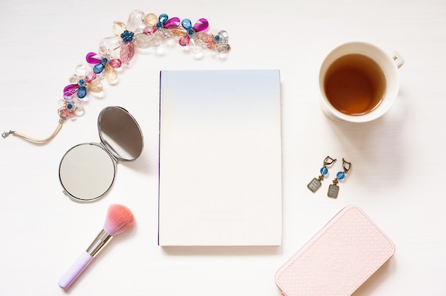 Libro en blanco aislado en fondo blanco con textura de madera con accesorios de mujer linda