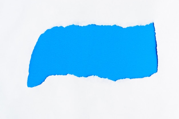 Libro blanco rasgado en un copyspace azul del fondo para el mensaje