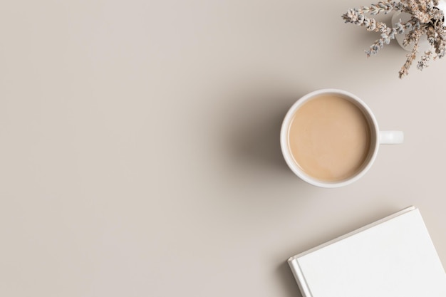 Libro blanco taza de café y lavanda en una mesa beige Plano con espacio de copia en blanco