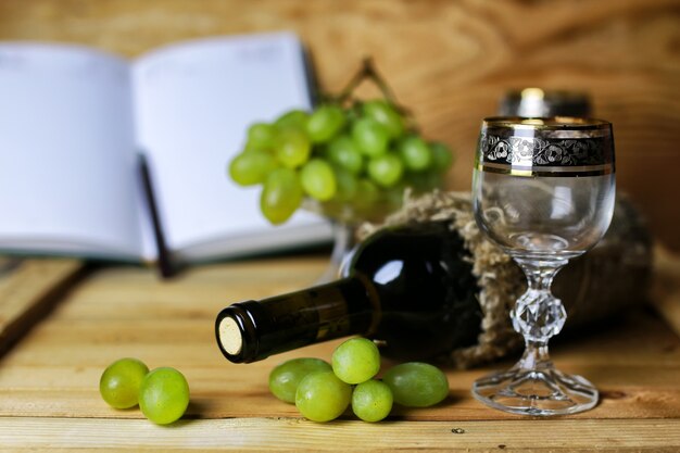 Libro de botella de vino y uva de cristal.