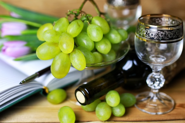 Libro de botella de vino y uva de cristal.
