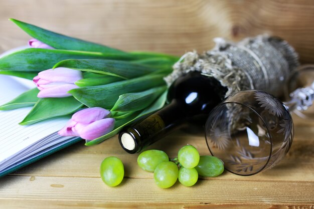 Libro de botella de vino y uva de cristal.