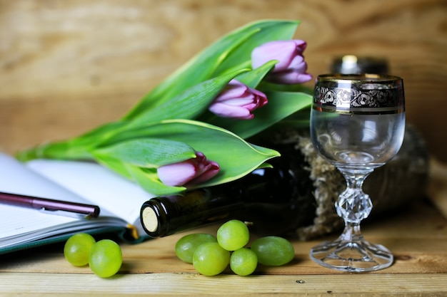 Libro de botella de vino y uva de cristal.