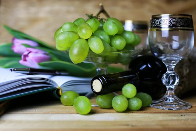 Libro de botella de vino y uva de cristal.
