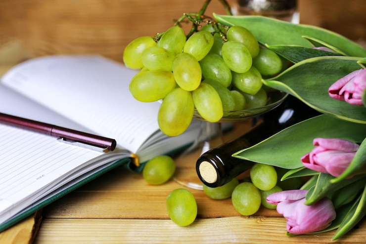 Foto libro de botella de vino y uva de cristal.