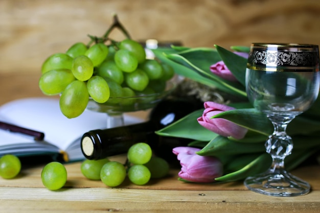 Libro de botella de vino y uva de cristal.