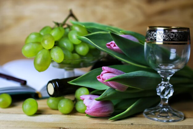 Libro de botella de vino y uva de cristal.