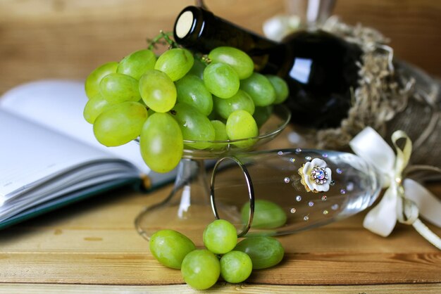 Libro de botella de vino y uva de cristal.