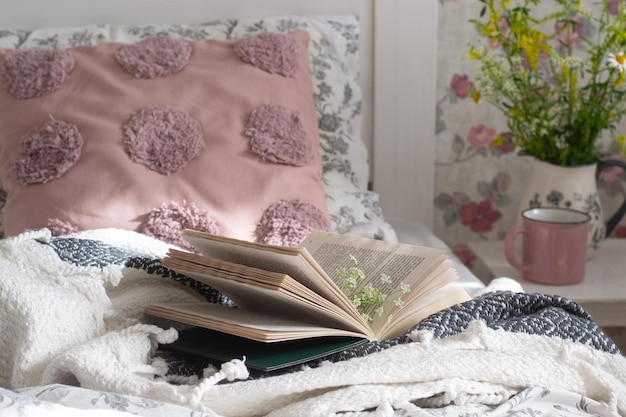 Foto libro en la cama en el dormitorio con flores papel tapiz luz del sol de la mañana
