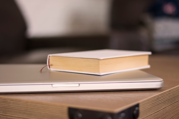 Libro y computadora portátil en una mesa de madera