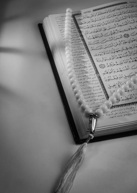 Un libro del Corán con una cuenta de oración blanca.