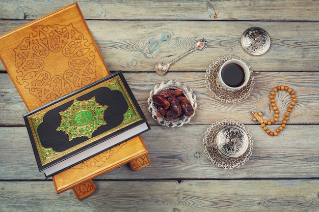 Libro del Corán con fechas y taza de café.