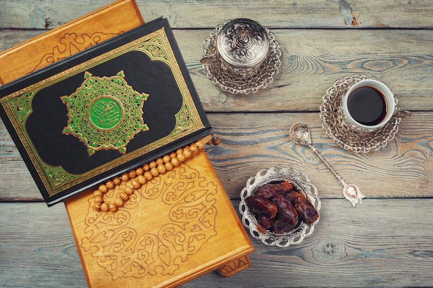 Libro del Corán con fechas y taza de café.