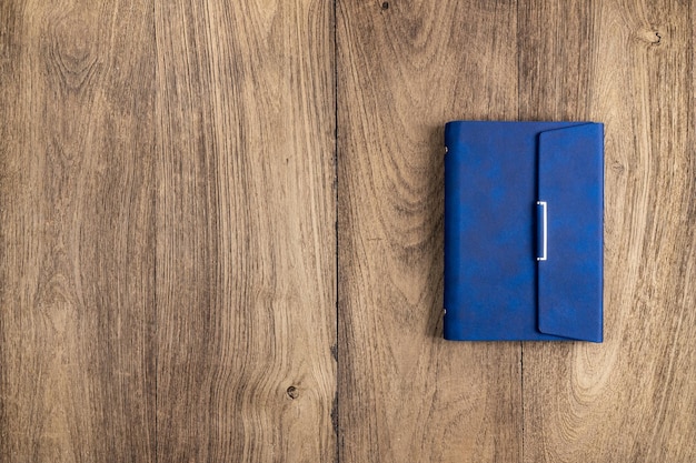 Libro de diario azul sobre una vieja mesa de madera de textura hermosa