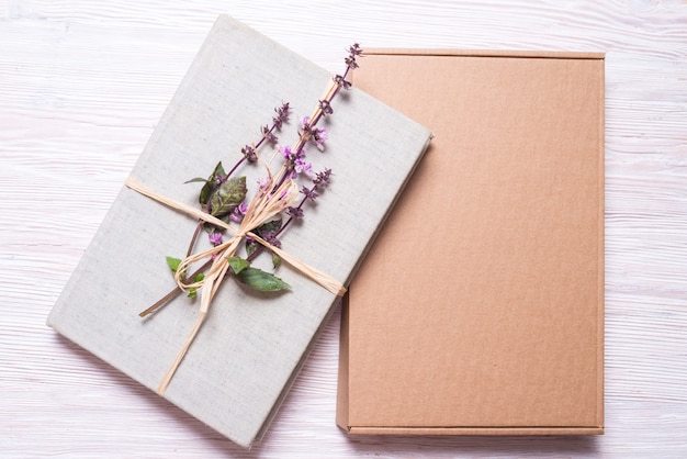 Libro envuelto con flores en caja de regalo de cartón