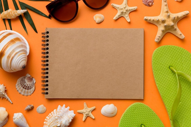 Libro de escritura en blanco con accesorios de playa de verano en el espacio de copia de fondo Plano con espacio de copia