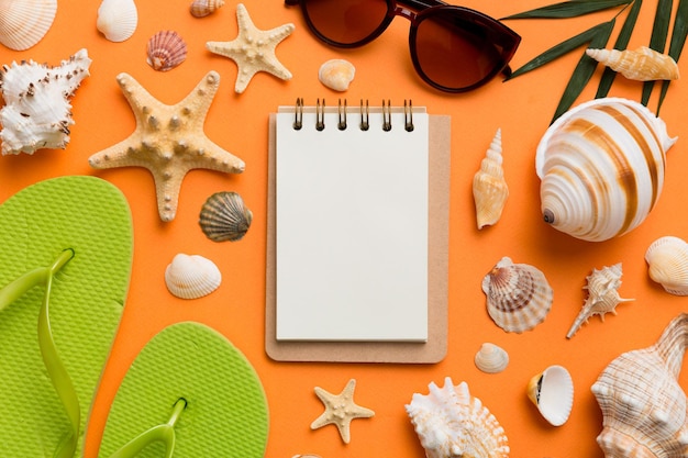 Libro de escritura en blanco con accesorios de playa de verano en el espacio de copia de fondo Plano con espacio de copia