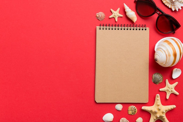 Libro de escritura en blanco con accesorios de playa de verano en el espacio de copia de fondo Plano con espacio de copia