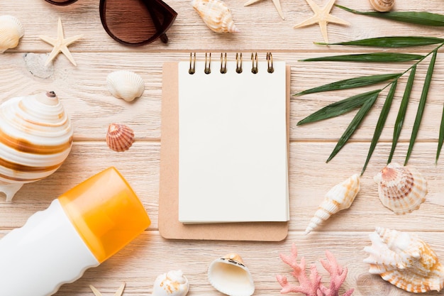 Libro de escritura en blanco con accesorios de playa de verano en el espacio de copia de fondo Plano con espacio de copia