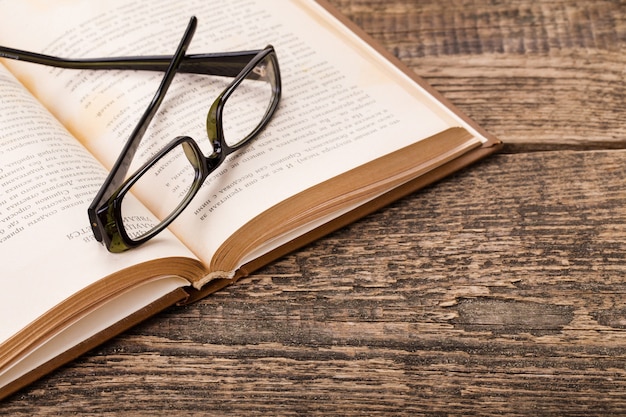 Libro y gafas en paleta de madera