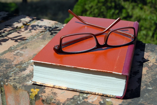 Libro y gafas en la pared al aire libre