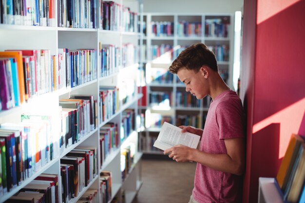 Libro de lectura de colegial en biblioteca