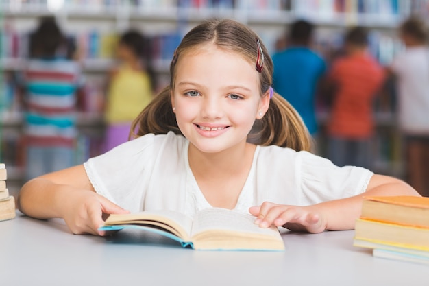 Libro de lectura de colegiala en biblioteca