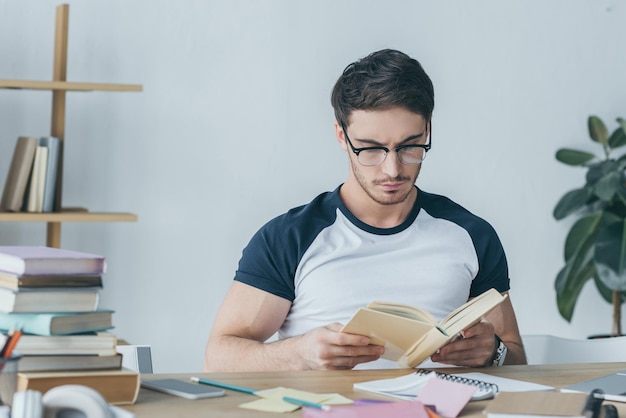 Libro de lectura de estudiante masculino guapo