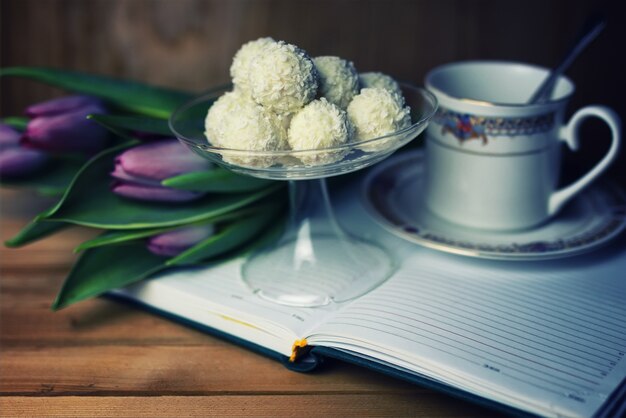 Libro de lectura con flor de té y dulce.