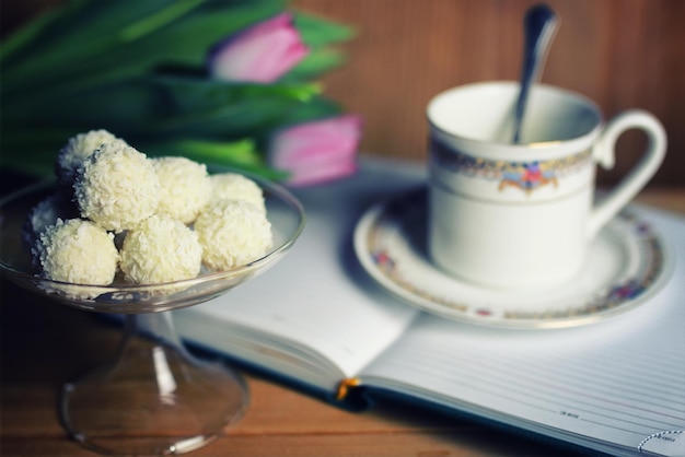 Libro de lectura con flor de té y dulce.